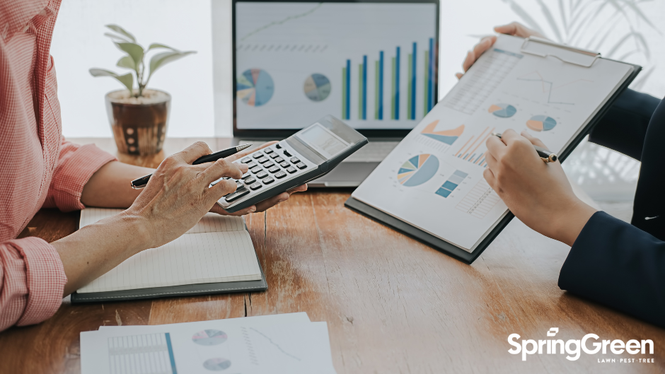 two people in a business meeting looking at charts and graphs to strategize for small business growth